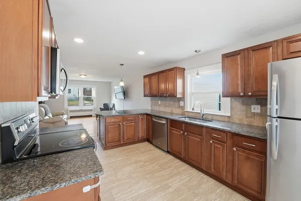 a view of a dining room with furniture and a kitchen