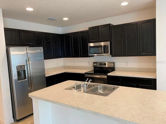 a kitchen with a refrigerator and a sink