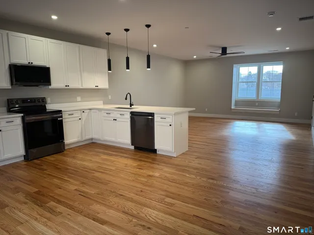 a kitchen with stainless steel appliances granite countertop a stove a sink and a microwave