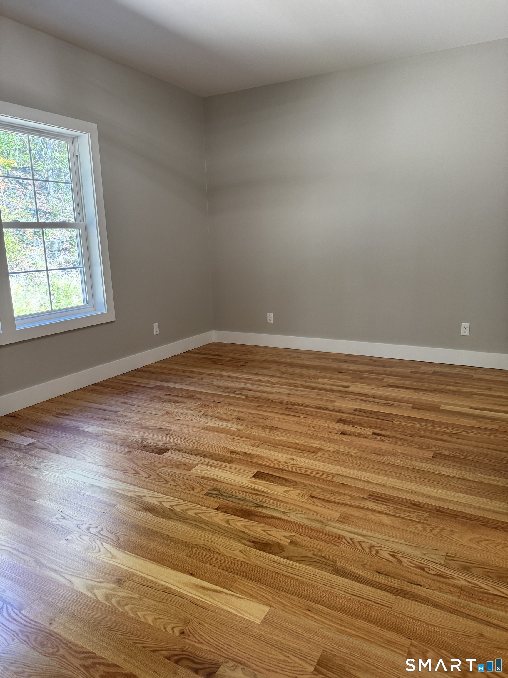 243 Echo Lake Road, Unit B12 Watertown, CT 06795 - Photo 11 of 11 an empty room with wooden floor and windows