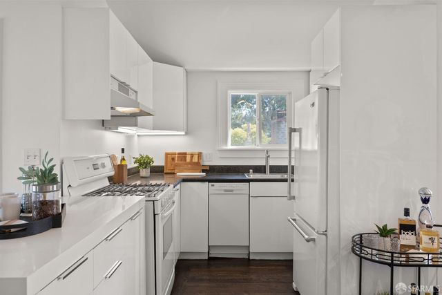 a kitchen with appliances a sink and cabinets
