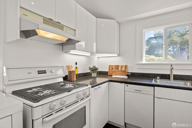 a kitchen with stainless steel appliances a sink stove and cabinets