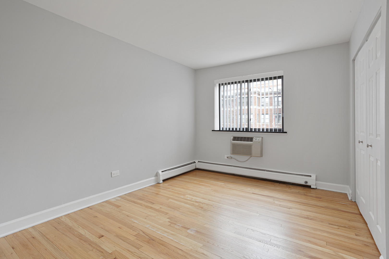 6758 North Sheridan Road, Unit 232 Chicago, IL 60626 - Photo 6 of 12 an empty room with wooden floor and windows