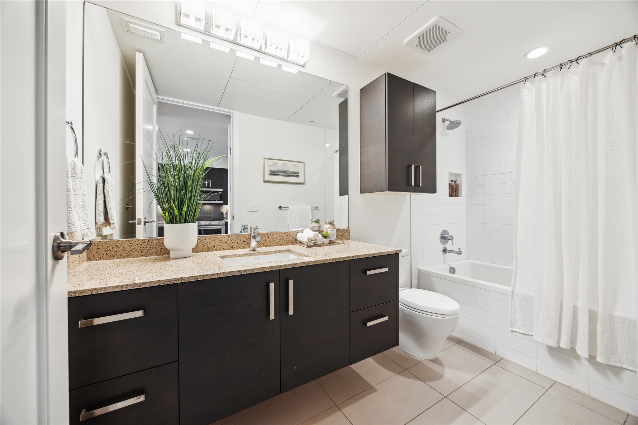 222 West Avenue, Unit 2403 Austin, TX 78701 - Photo 9 of 38 a bathroom with a granite countertop sink toilet mirror and bathtub