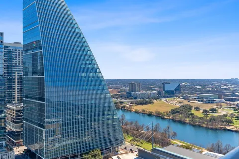 a living room with furniture kitchen view and large windows