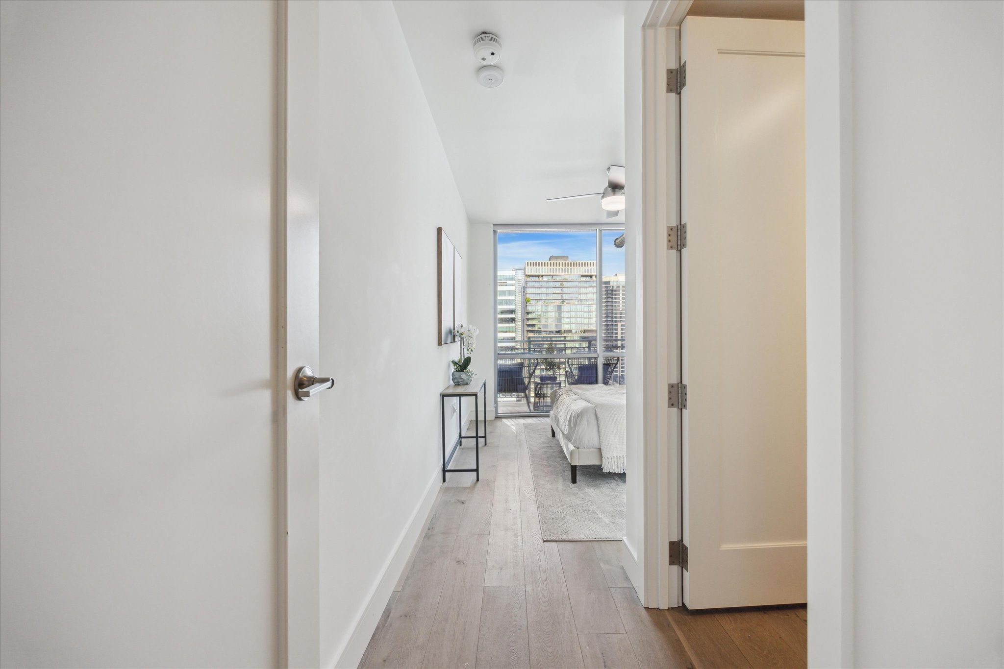 222 West Avenue, Unit 2403 Austin, TX 78701 - Photo 6 of 38 a hallway with white doors wooden floor and front door