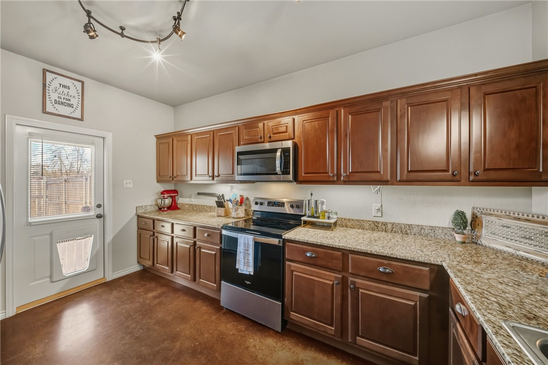 3205 Corporal Road College Station, TX 77845 - Photo 8 of 29 a kitchen with stainless steel appliances granite countertop a stove sink microwave and window
