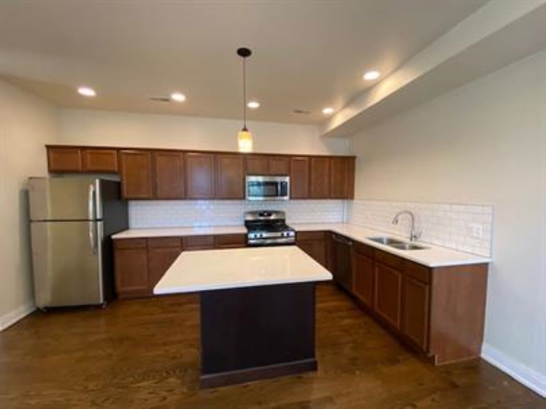 1734 West 35th Street, Unit 2F Chicago, IL 60609 - Photo 4 of 7 a large kitchen with kitchen island a sink dishwasher a stove and a refrigerator with wooden floor