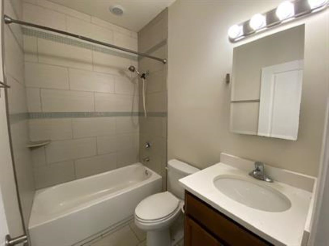 1734 West 35th Street, Unit 2F Chicago, IL 60609 - Photo 6 of 7 a bathroom with a sink toilet vanity and shower
