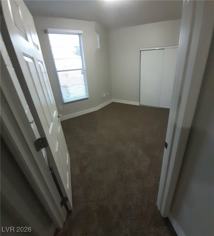 8555 West Russell Road, Unit 2018 Las Vegas, NV 89113 - Photo 17 of 31 Unfurnished bedroom featuring dark carpet and a closet