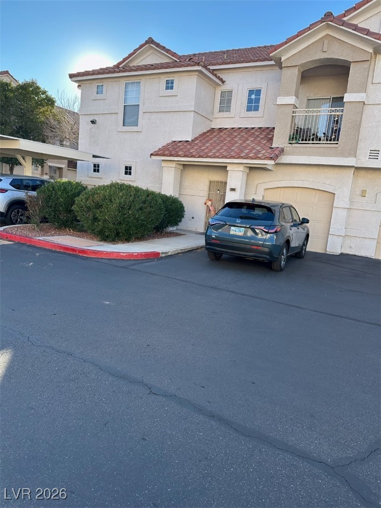 8555 West Russell Road, Unit 2018 Las Vegas, NV 89113 - Photo 7 of 31 View of front of property featuring stucco siding, asphalt driveway, a balcony, and a tile roof