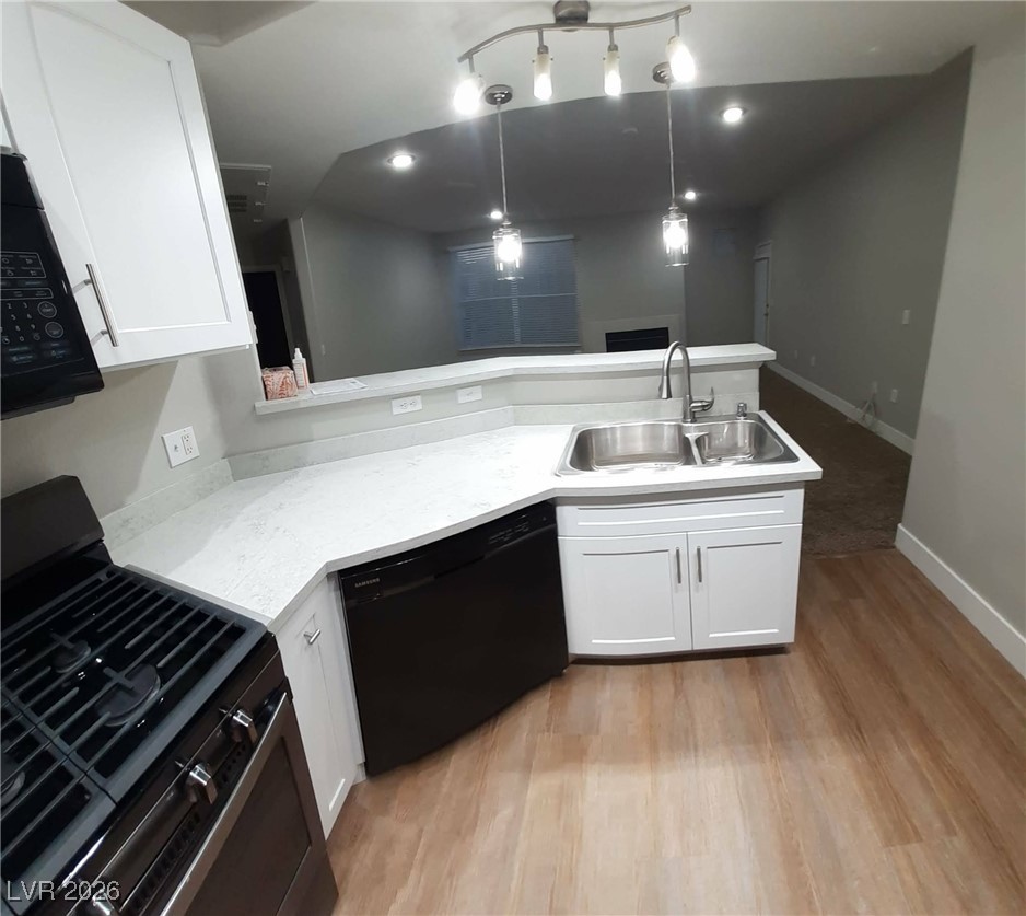 8555 West Russell Road, Unit 2018 Las Vegas, NV 89113 - Photo 8 of 31 Kitchen with black appliances, a peninsula, white cabinets, decorative light fixtures, and light wood-style floors