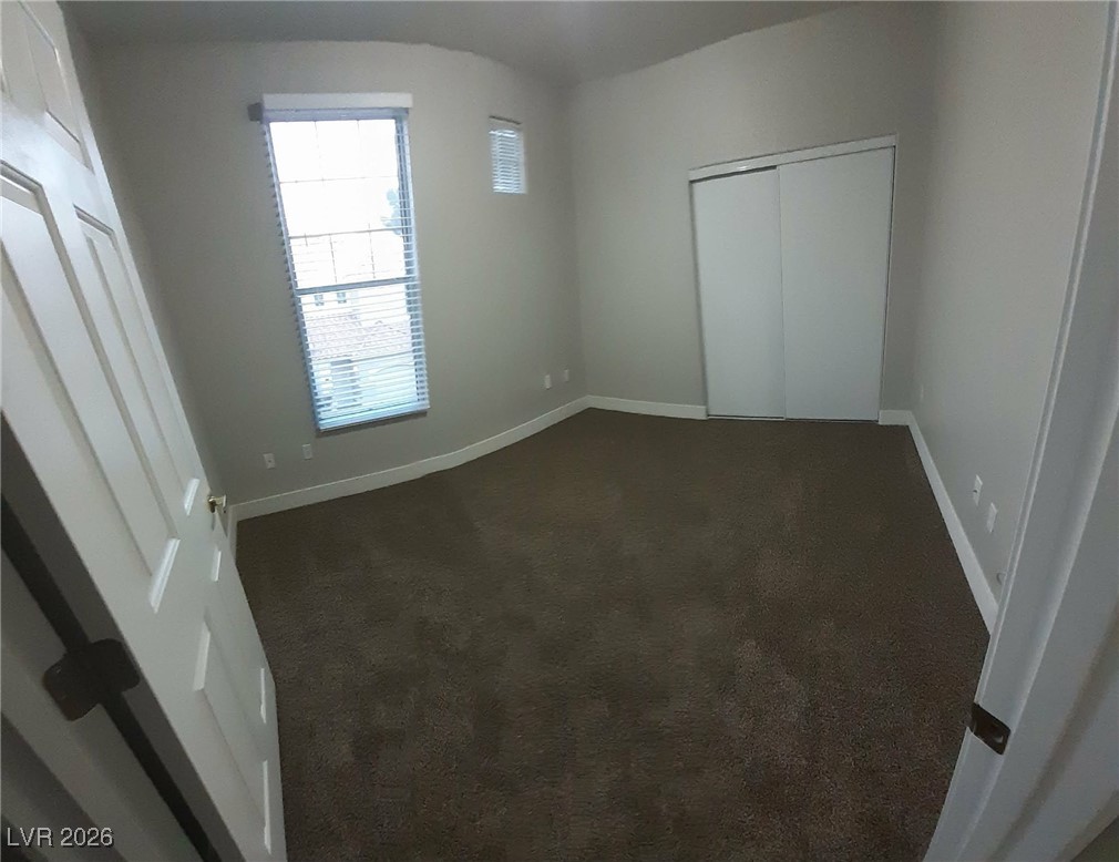 8555 West Russell Road, Unit 2018 Las Vegas, NV 89113 - Photo 10 of 31 Unfurnished bedroom featuring dark carpet and a closet