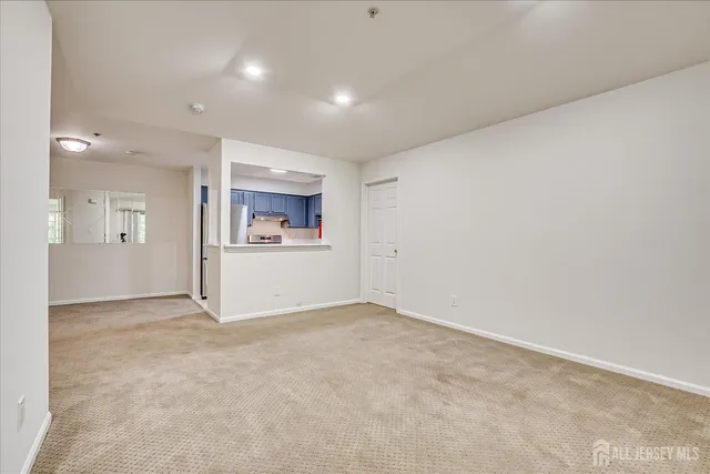 an empty room with a white wall and a refrigerator