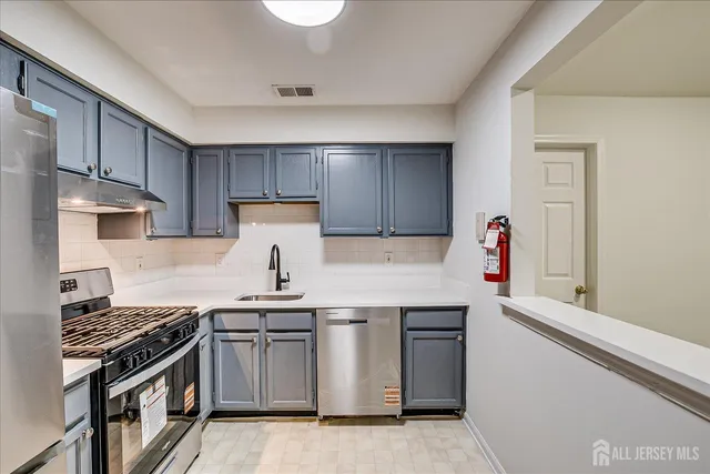 a view of a kitchen with a sink and dishwasher a refrigerator with wooden floor