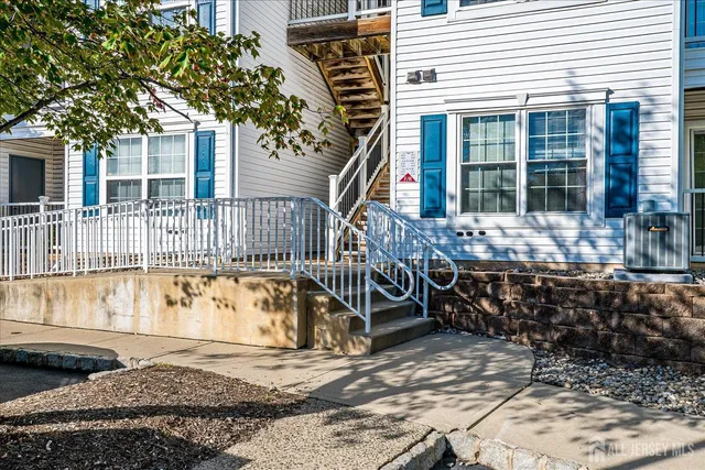 a front view of a house with a large tree