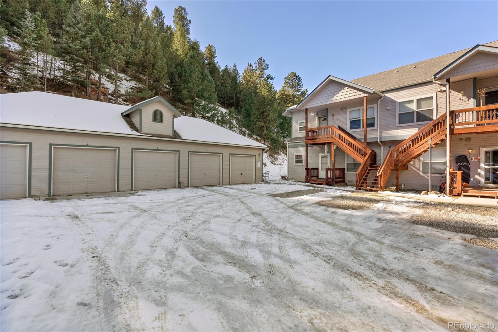 5720 County Road 64, Unit 101A Bailey, CO 80421 - Photo 2 of 46 a front view of a house with a yard and garage