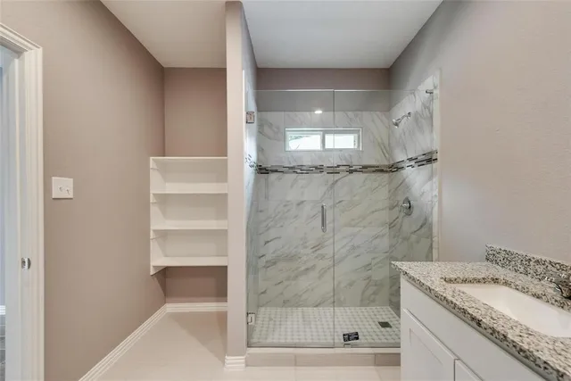 a bathroom with a granite countertop sink a mirror and shower