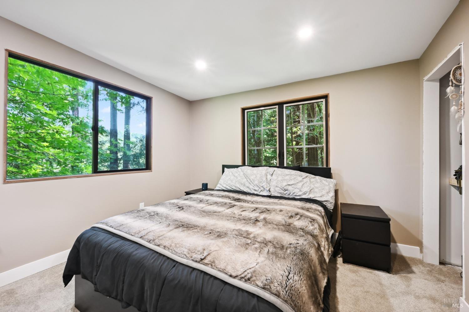 21713 Starrett Hill Drive Monte Rio, CA 95462 - Photo 25 of 50 a bed sitting in a spacious bedroom next to a window