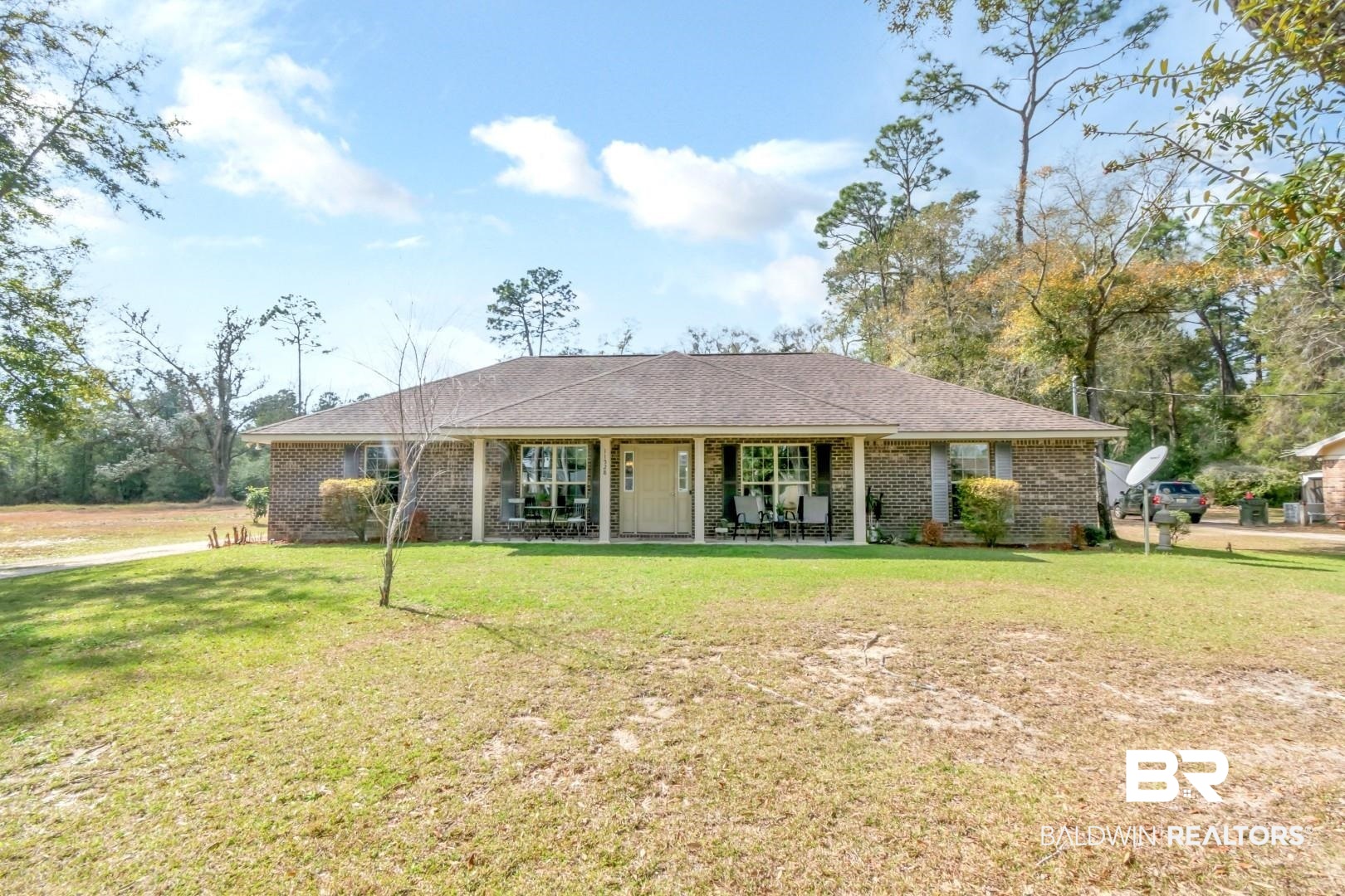 11528 Mocking Bird Lane Fairhope, AL 36532 - Photo 1 of 45 Ranch-style home with brick siding, a front yard, roof with shingles, and covered porch