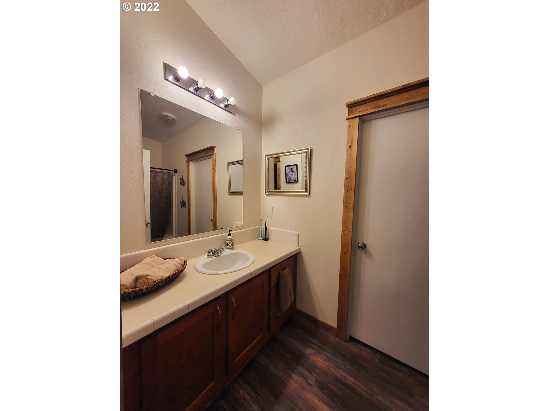 67506 East Bay Road North Bend, OR 97459 - Photo 13 of 31 a en suite bathroom with a double vanity sink and a mirror