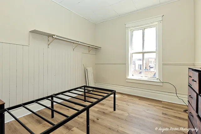 a picture of a room with wooden floor and a window