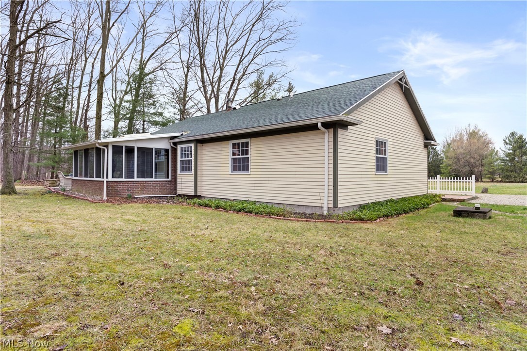 11923 Green Road Wakeman, OH 44889 - Photo 34 of 45 View of side of home featuring a sunroom and roof with shingles