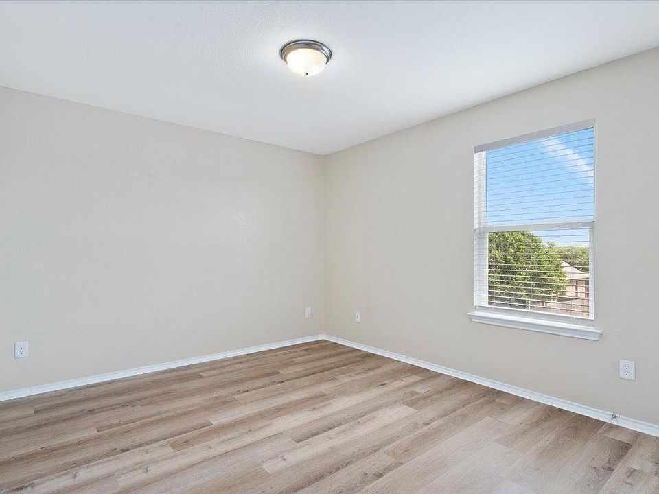 904 Lonesome Lilly Way Pflugerville, TX 78660 - Photo 29 of 34 This room features light-colored walls, wood-style flooring, and a window with blinds providing natural light