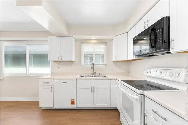 a kitchen with white cabinets stainless steel appliances and sink