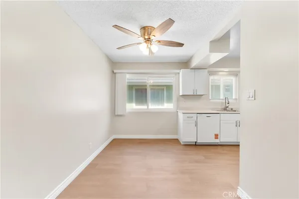 an empty room with a ceiling fan and window