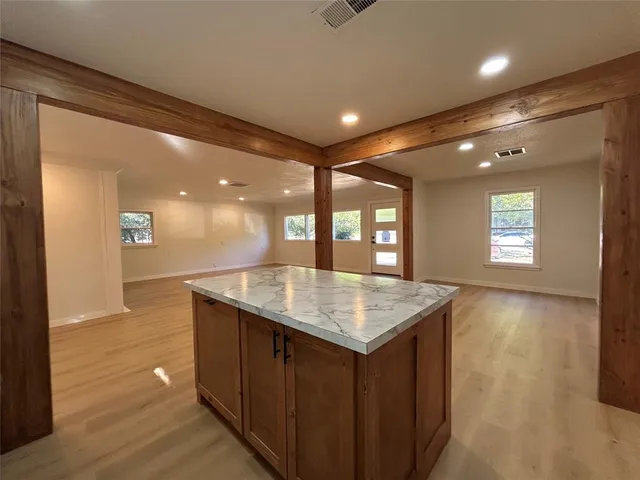 a kitchen with a wooden floor and large window