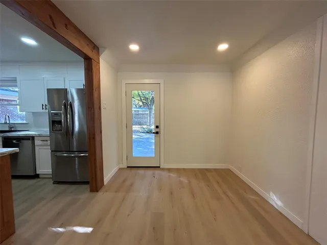 a view of an empty room with a fireplace and a window