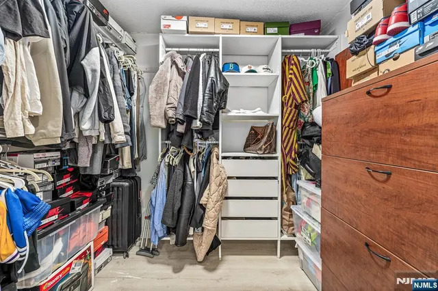 a view of walk in closet with clothes and shoes