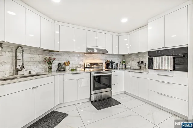 a kitchen with cabinets stainless steel appliances and a sink