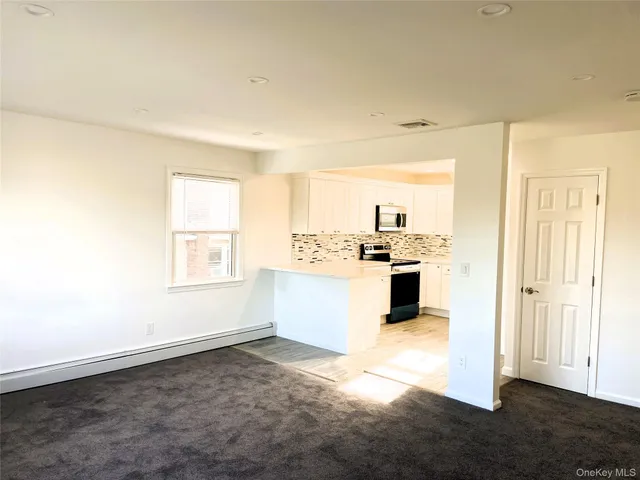 a view of a kitchen with wooden floor and electronic appliances
