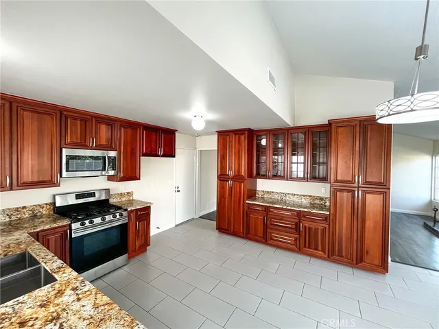 a kitchen with stainless steel appliances granite countertop a stove a sink and a refrigerator