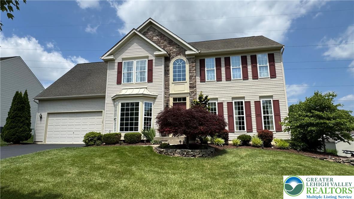 a front view of a house with a yard and garage