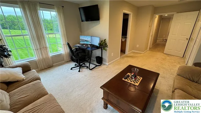 a view of staircase with lots of frames on wall and windows