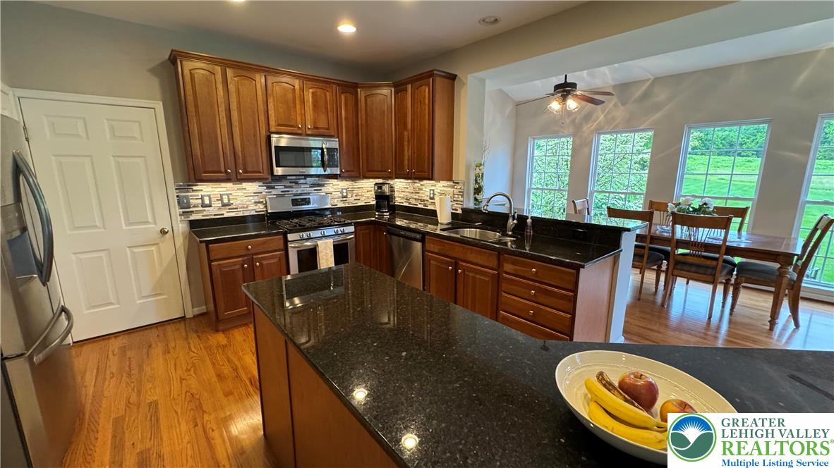 135 Clover Hollow Road Easton, PA 18045 - Photo 53 of 66 a kitchen with kitchen island granite countertop a stove a sink a dining table and chairs