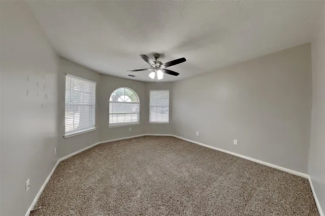 a view of a livingroom with a ceiling fan and window