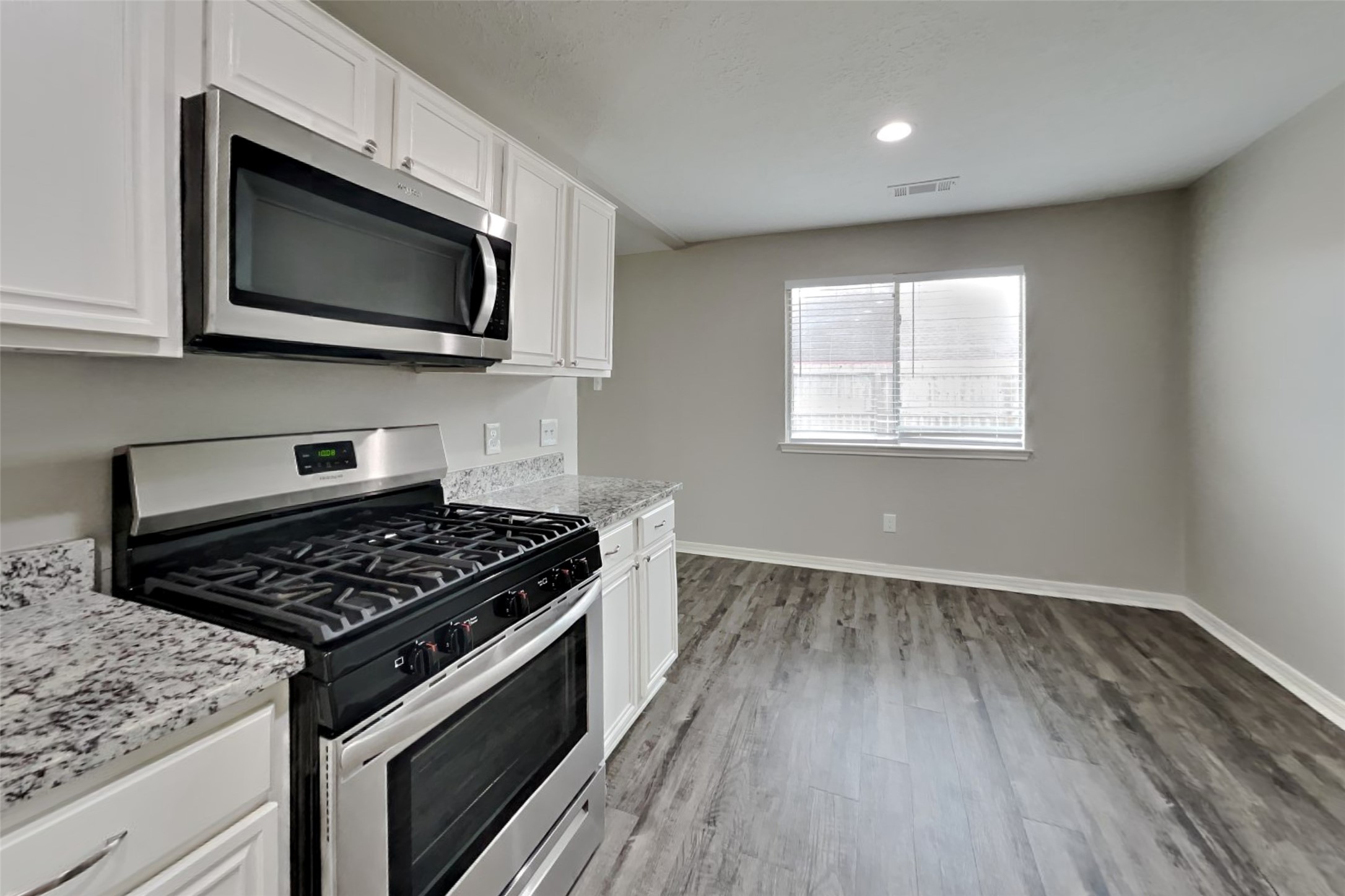 3413 Jan Court Katy, TX 77493 - Photo 5 of 18 a kitchen with granite countertop a stove and a microwave