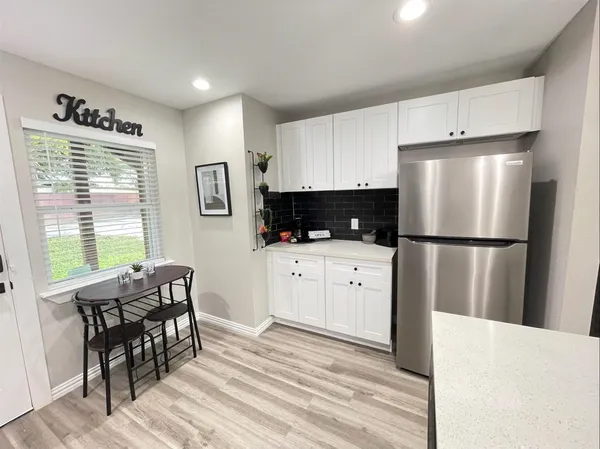 a kitchen with stainless steel appliances a refrigerator sink and wooden cabinets