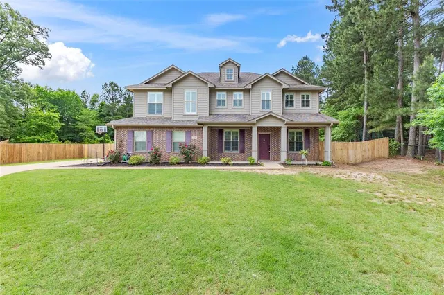 a front view of a house with a yard and potted plants