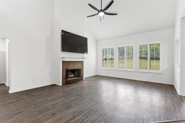 a view of a livingroom with a fireplace wooden floor and window