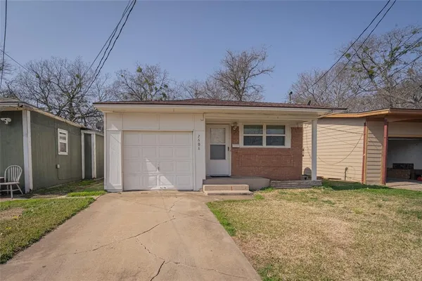 a front view of house with yard and trees in the background