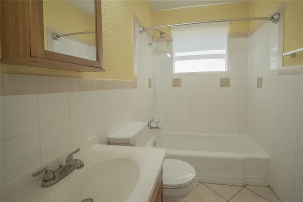 an empty room with a window and a ceiling fan