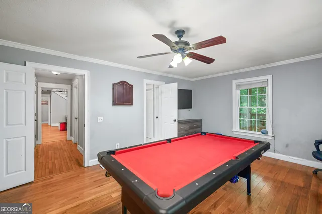 a room with pool table and windows