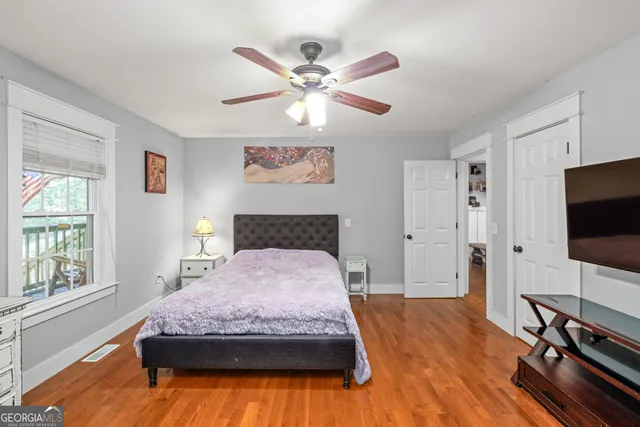 a bedroom with a bed window and a flat screen tv