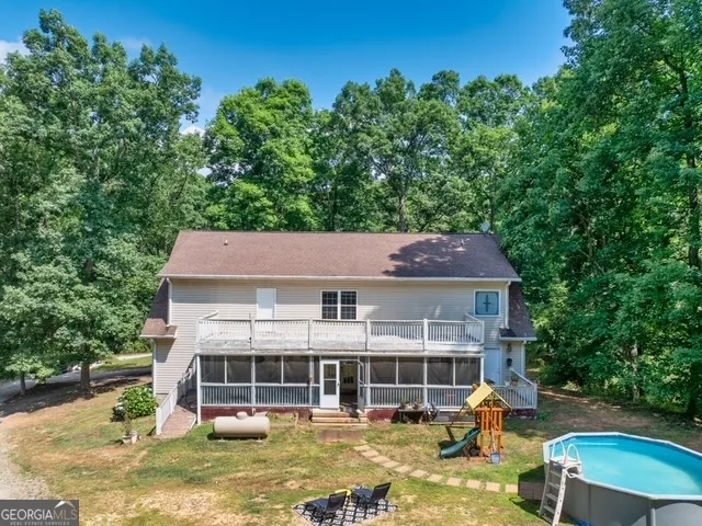a view of a house with a yard and swimming pool