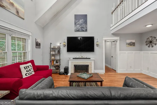 a living room with furniture a flat screen tv and a fireplace